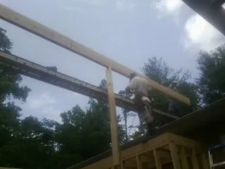 Carpenter setting a ridge beam over a new addition frame — Ice Dam Removal by Roofing Brothers in Watkinsville