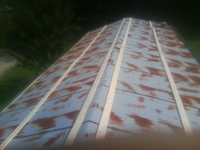 Rusted metal roof panels with new wood purlins before replacement — Storm Damage Roof Repair in Watkinsville by Roofing Brothers