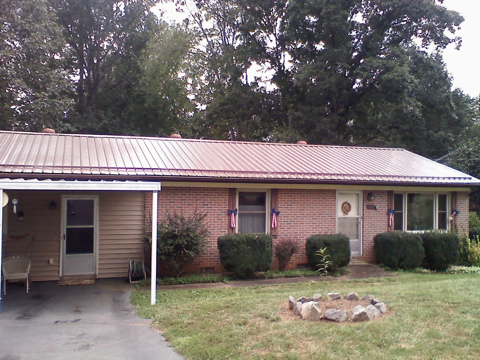 Bronze metal roof and carport on a brick ranch home — Roof Repair work by our crew in Watkinsville